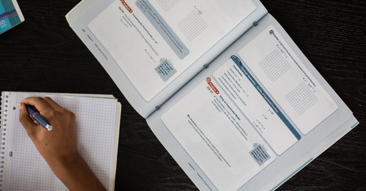 How to Solve Glitch Preventing Me From Attacking! - Top view of faceless African American student taking notes in notepad while sitting at table with textbook during lesson in class