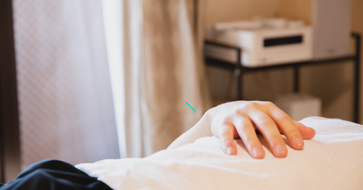 How to solve the problem of "No relief from work! Leaving!"? - Crop anonymous male client with needle in hand lying on couch during treatment therapy in salon