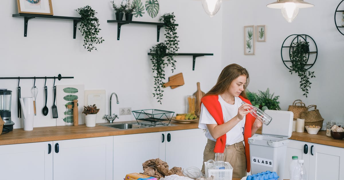 How to sort different output (like Plastic and Waste)? - Young woman utilizing wastes in modern kitchen How to sort different output (like Plastic and Waste)? - Young woman utilizing wastes in modern kitchen