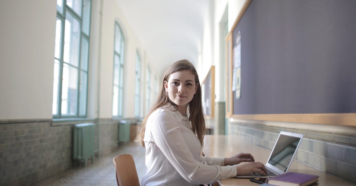 How to stack runes of same type? - Female student typing on laptop in university hallway