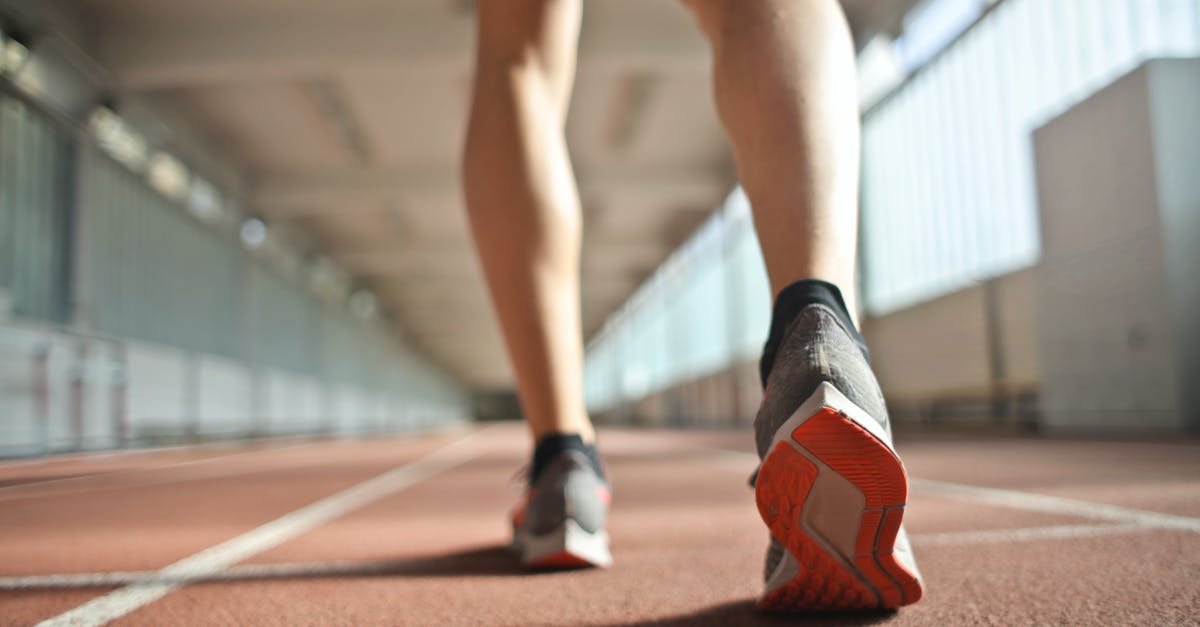 How to start with the most Health? - Fit runner standing on racetrack in athletics arena
