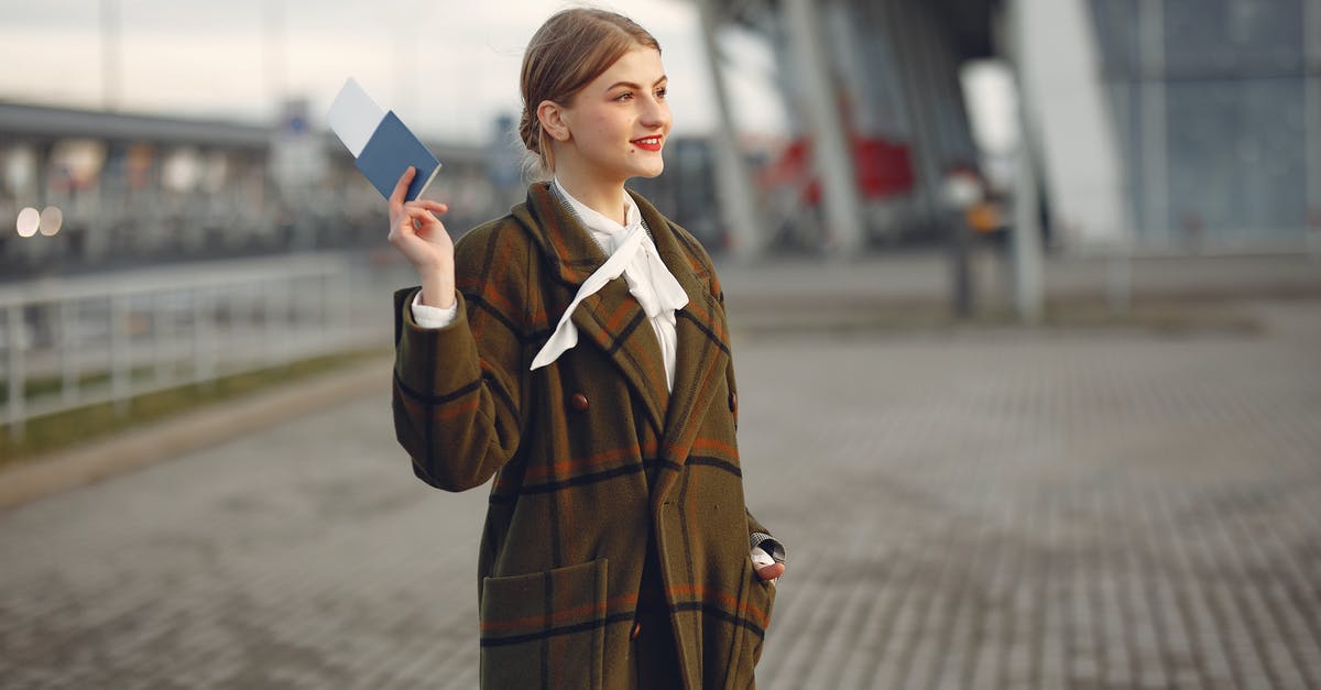 How to take away only one of multiple items [duplicate] - Cheerful female passenger wearing trendy plaid coat taking passport and ticket in raised hand while standing on pavement near modern building of airport outside and looking away with smile
