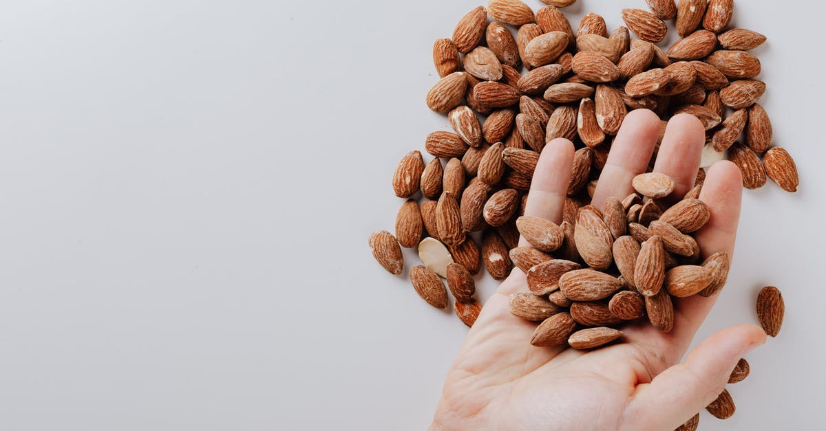How to take off the entire top of a PS4 - From above of anonymous male taking tasty organic almonds from pile of nuts placed on white background isolated illustrating healthy food concept