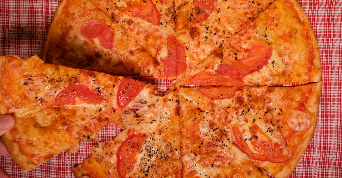 How to take off the entire top of a PS4 - Top view of crop anonymous person taking slice of yummy pizza with tomato and oregano placed on checkered tablecloth