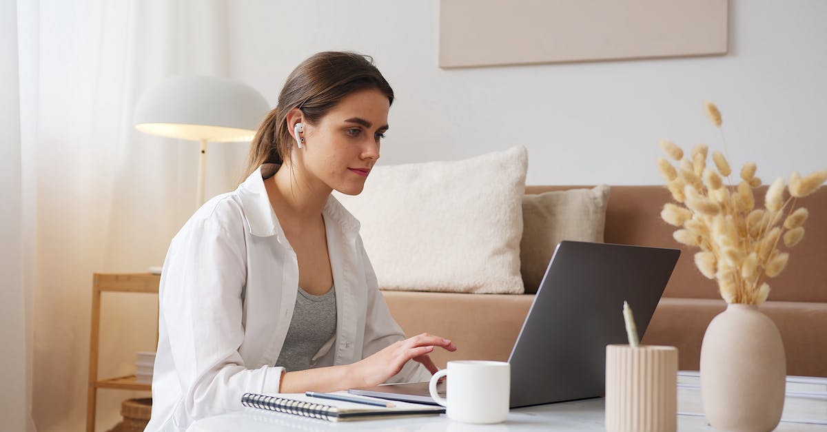 How to talk to the living? - Thoughtful woman with earbuds using laptop How to talk to the living? - Thoughtful woman with earbuds using laptop