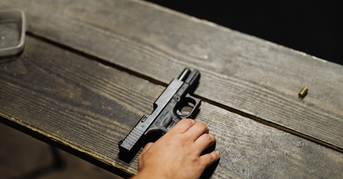 How to tell if a weapon is one or two-handed - Hand of a Person Holding Black Semi Automatic Pistol