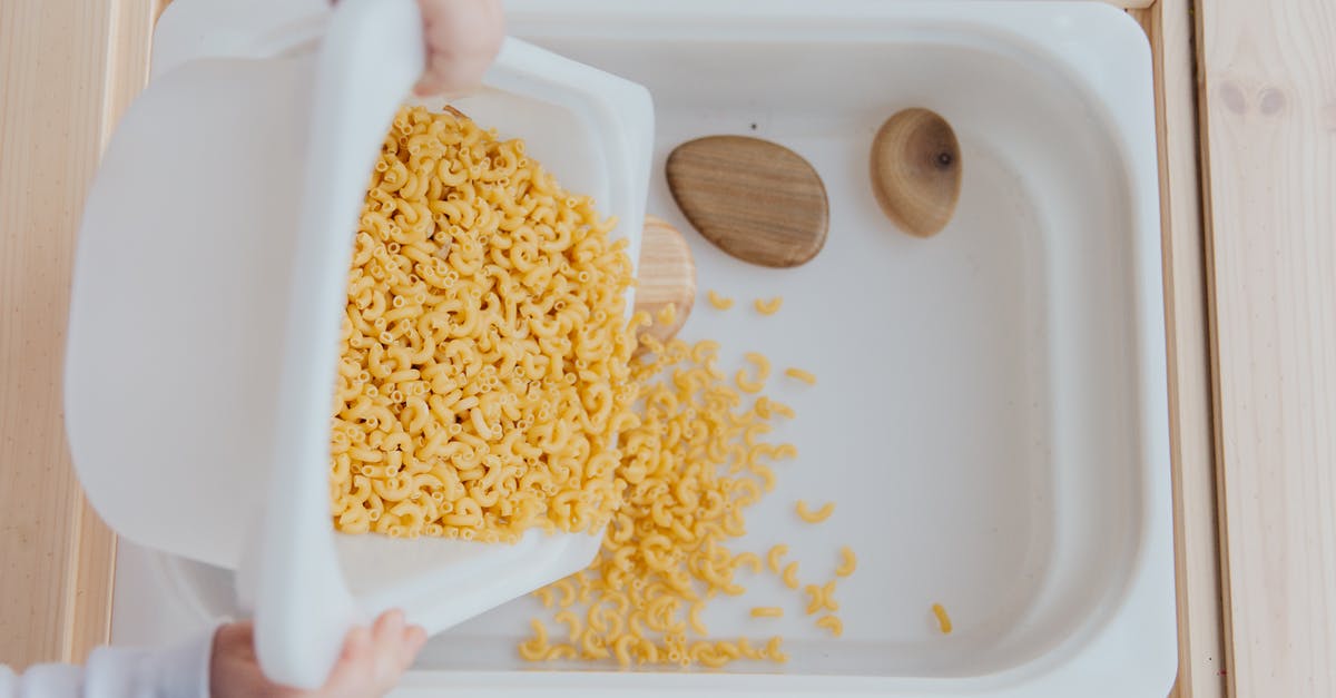 How to tell if Wii U can play this game on product page? - Unrecognizable crop kid adding raw pasta to white container