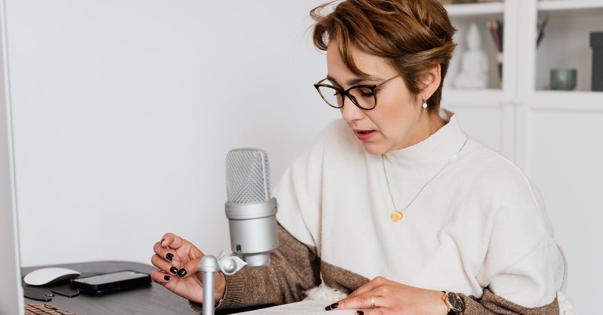 How to tell Max CP? - Female narrator in glasses reading out loud from book while sitting at desk with microphone and recording audiobook in cozy study How to tell Max CP? - Female narrator in glasses reading out loud from book while sitting at desk with microphone and recording audiobook in cozy study