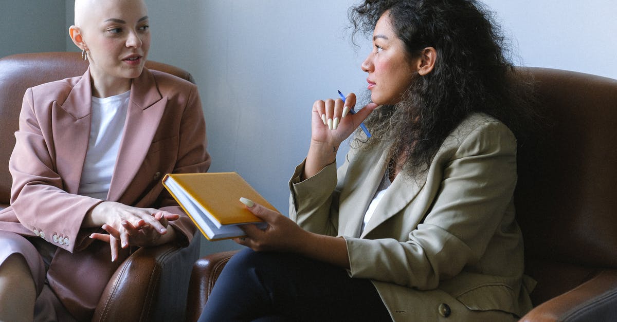 How to tell who lives in a Cell - Young female friends having conversation sitting in armchairs in room
