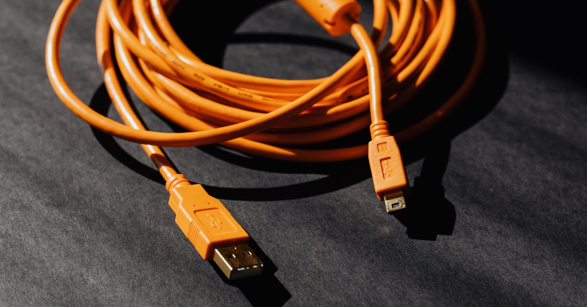 How to transfer Minecraft from Pocket Edition to PC Edition [duplicate] - From above of orange usb to micro usb cable twisted into ring placed on black board