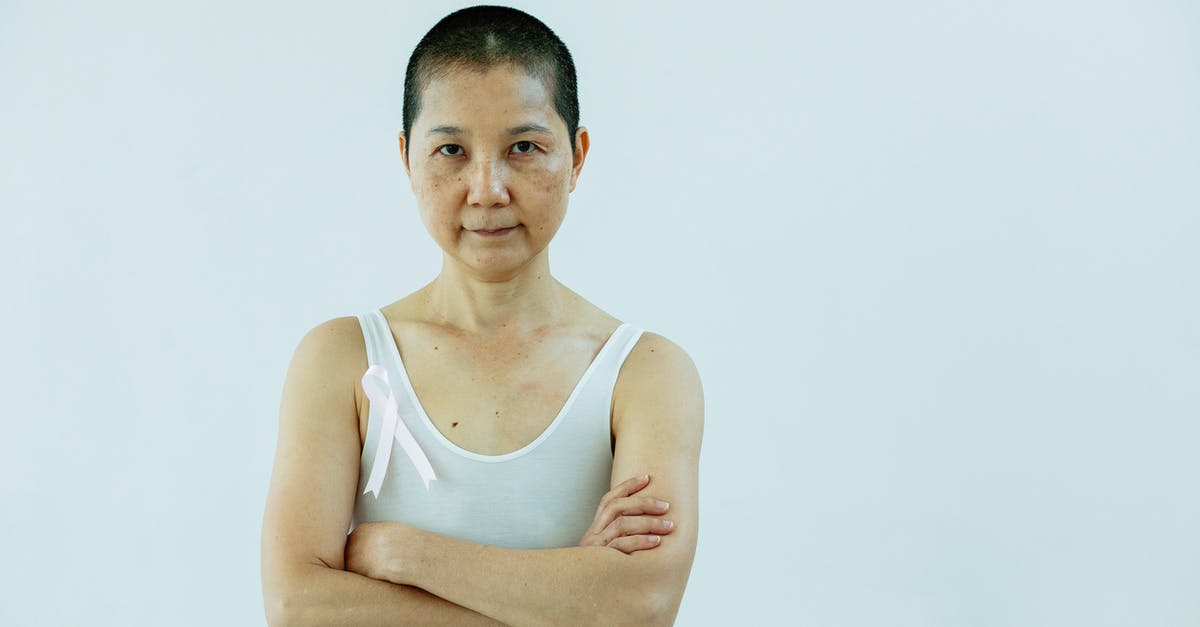 How to treat tiredness? - Asian woman with arms folded and breast cancer How to treat tiredness? - Asian woman with arms folded and breast cancer