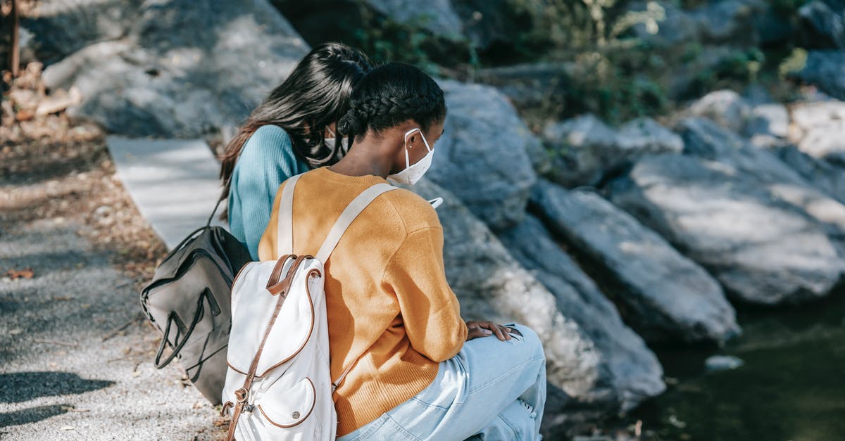 How to turn a salty water into normal, drinkable water? - Multiethnic women in medical masks on asphalt step in park