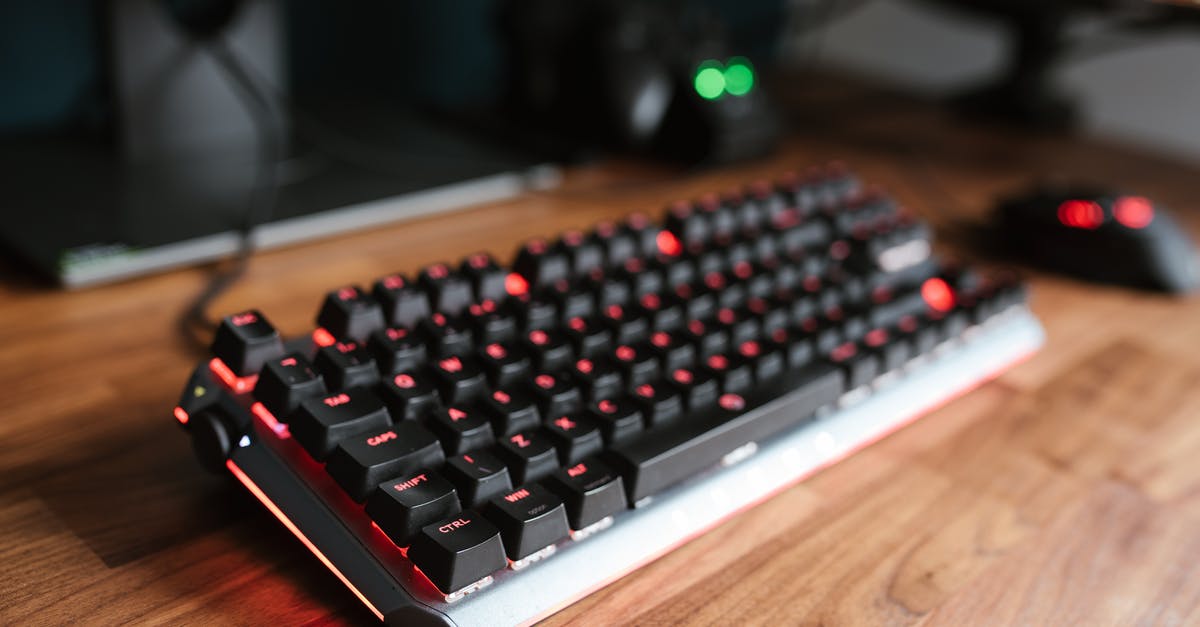 How to use hotkeys when focused program disables them? - Contemporary computer backlit keyboard placed on wooden desk near mouse in light room