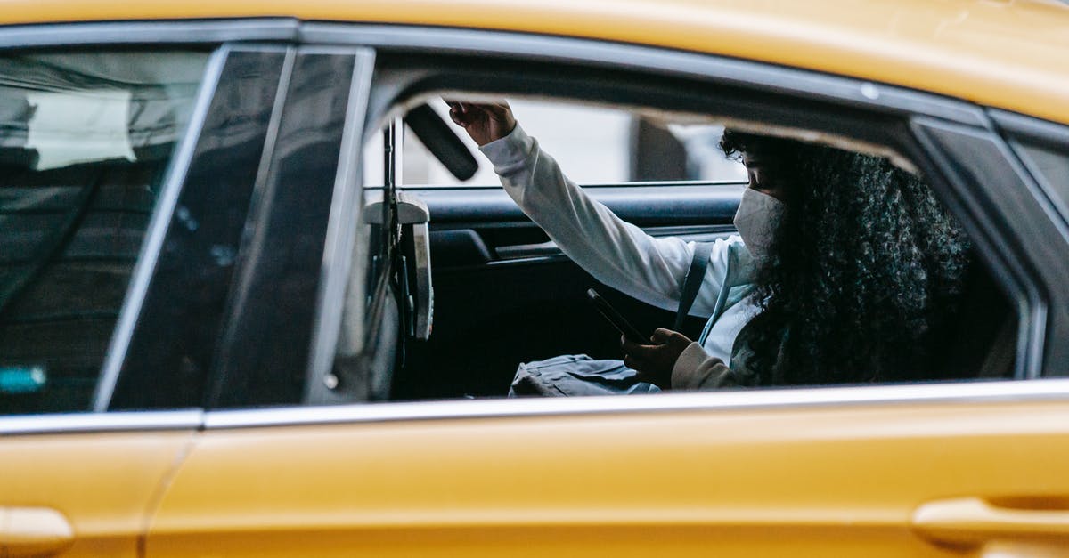 How to use the minecraft 1.9 "Passengers" tag? - Young black lady wearing protective mask and casual clothes sitting with backpack in yellow cab while surfing on smartphone with open window in street in daytime in town