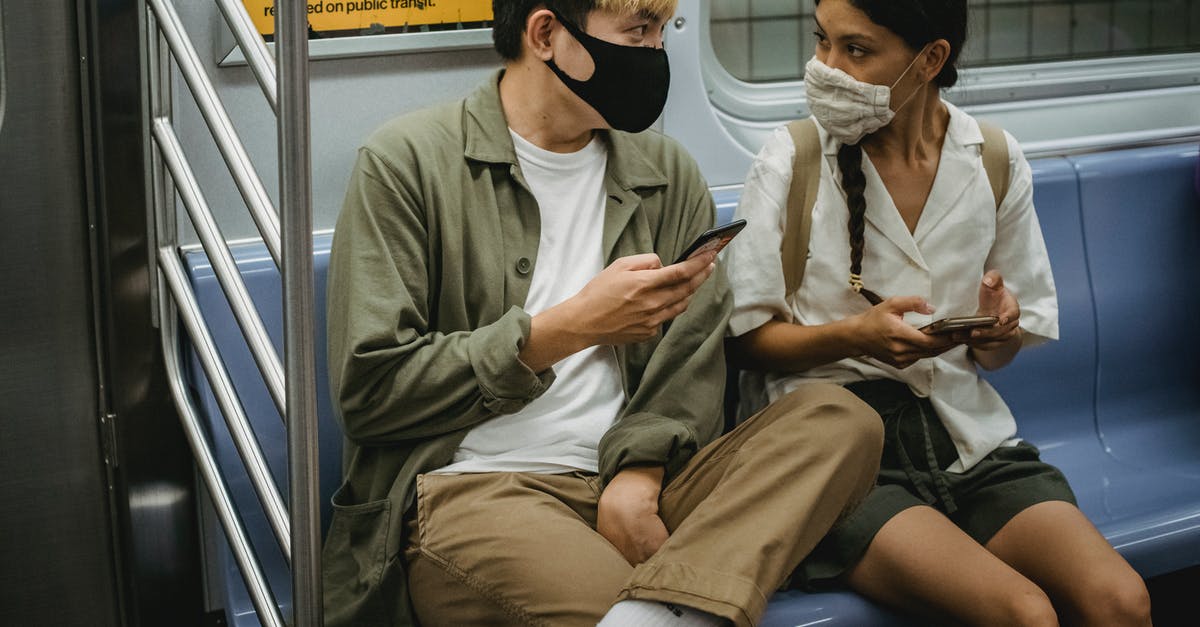 How to use the minecraft 1.9 "Passengers" tag? - Unrecognizable young Asian man and ethnic woman in face masks and casual clothes using mobile phones and chatting while riding train