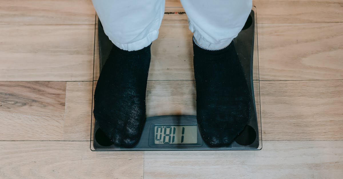 How to view balance sheet including trade profits/losses - From above of crop unrecognizable plus size person in casual clothes standing on weighing scale on wooden floor