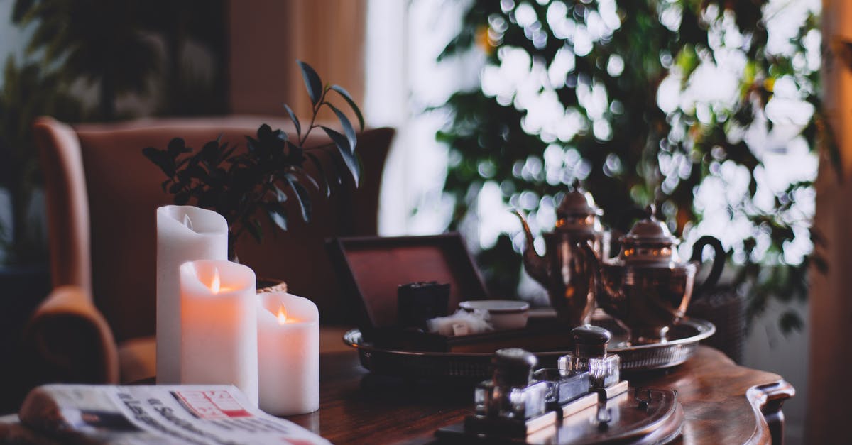 How was the house set on fire? - Flaming wax candles near metal teapots on tray and cozy armchair in house room How was the house set on fire? - Flaming wax candles near metal teapots on tray and cozy armchair in house room
