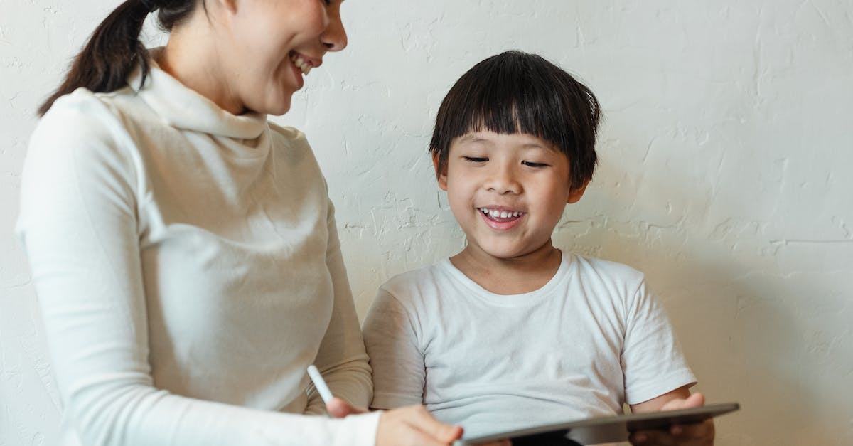 I can't log in to Minecraft please help - Crop ethnic mother browsing tablet with glad child