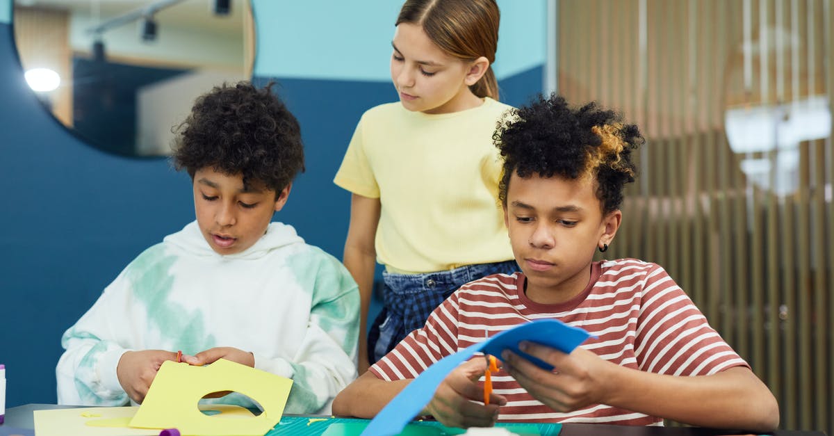 I downloaded the create mod in minecraft in a world that's already generated [duplicate] - Group of concentrated diverse schoolchildren sitting at table together and making paper crafts using scissors in light room