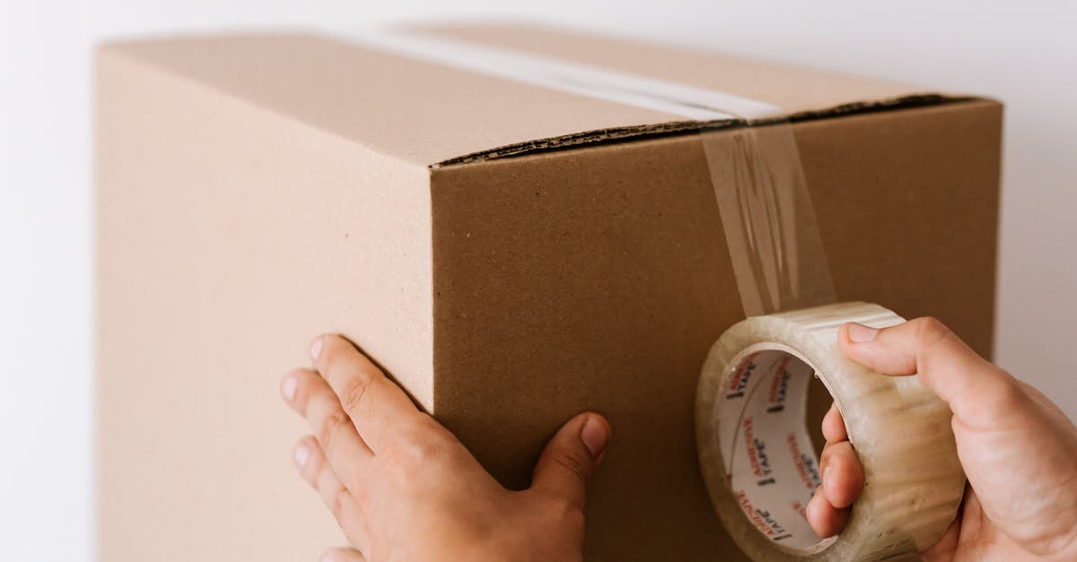 I just bought TF2 as part of the Valve Complete Pack. Where's my Proof of Purchase helmet? - Crop faceless male sealing packed carton box with tape against white wall in daylight during relocation
