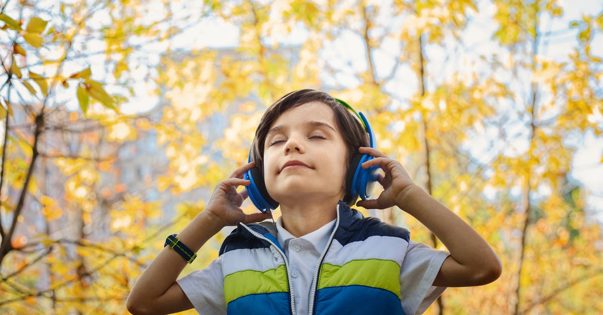 I keep hearing voices - Photo of a Boy Listening in Headphones