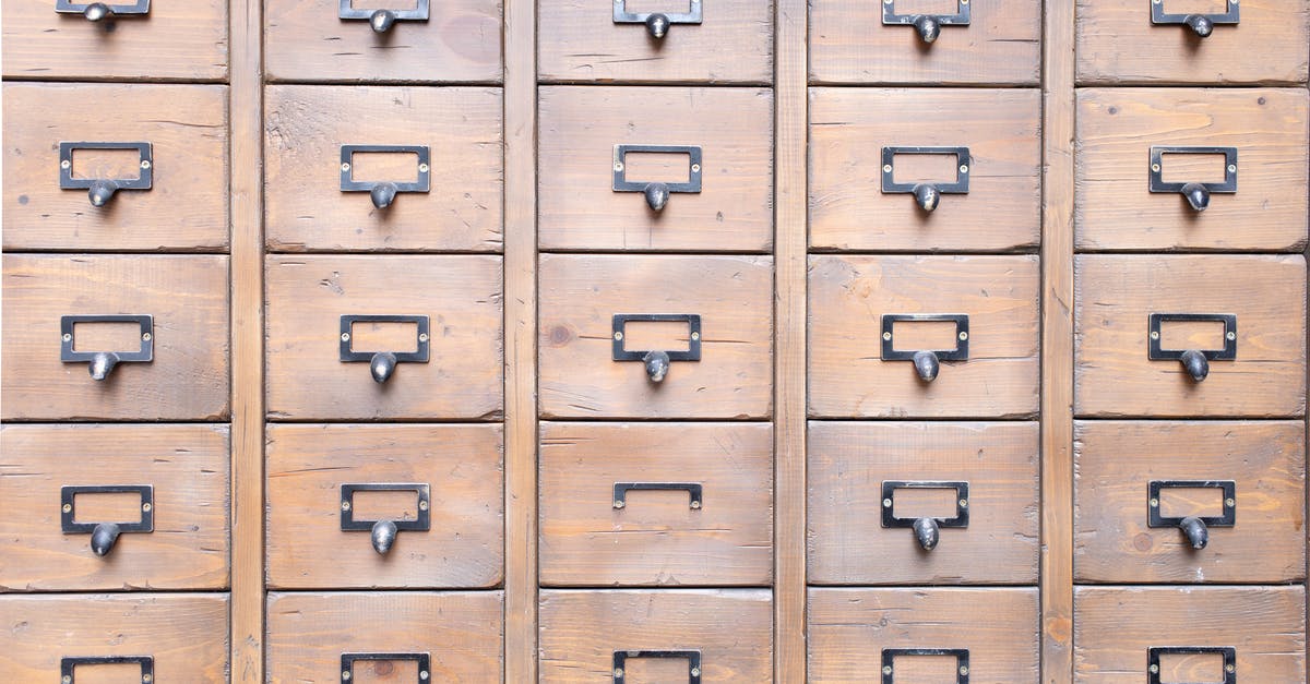I keep hearing voices - Background of wall full of many similar aged shabby vintage wooden drawers with metal round handles