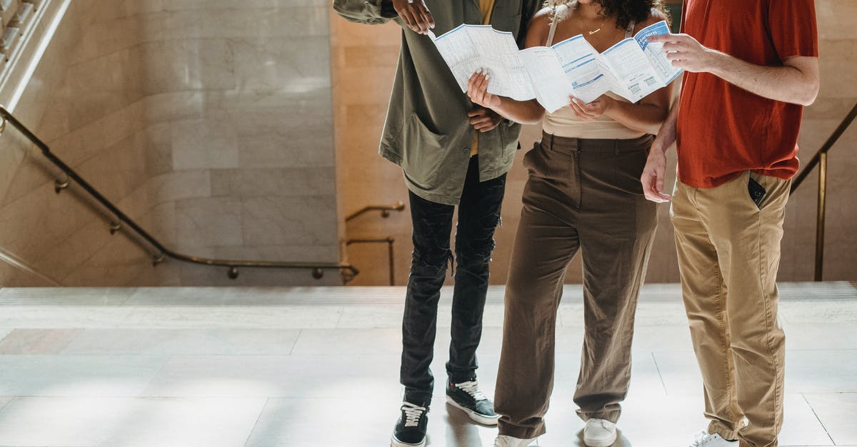 I Lost My Build [duplicate] - Concentrated young Hispanic lady reading map while standing near staircase of old building during vacation with crop multiethnic male friends