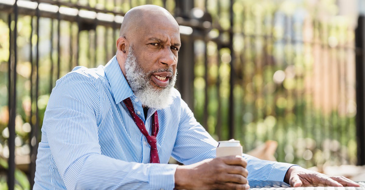 I think I'm stuck on an island. How can I escape it? - Sullen black man sitting at table with drink