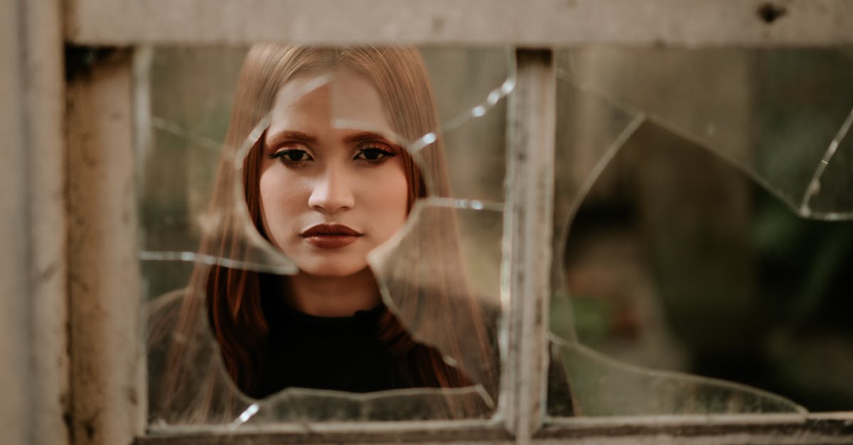 I think i have a soft ban? [duplicate] - Calm young woman looking at camera through broken window