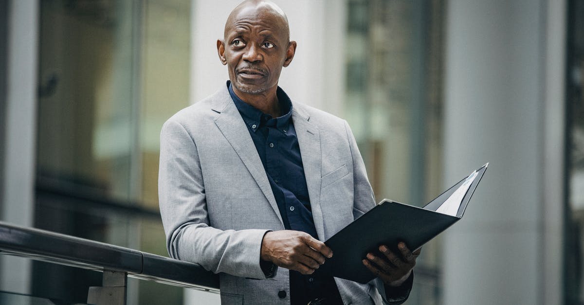I think i have a soft ban? [duplicate] - Confident African American manager in formal suit carrying folder with papers and looking away in soft daylight