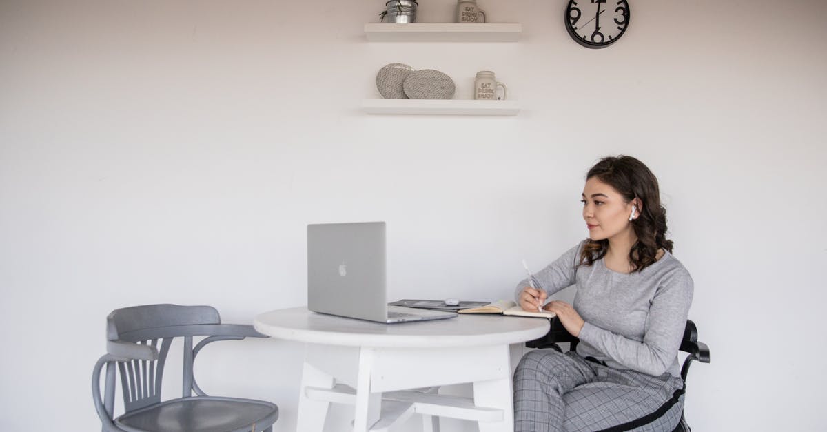 i used a tp command on a clock and am trapped [duplicate] - Ethnic female student in earbuds writing on copybook near laptop