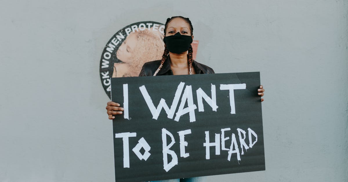 I want to be an assassin - A Woman Wearing Face Mask while Holding a Black Placard I want to be an assassin - A Woman Wearing Face Mask while Holding a Black Placard