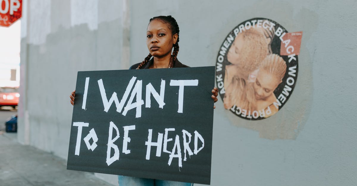 I want to be an assassin - A Protester Holding Black Placard with Message I want to be an assassin - A Protester Holding Black Placard with Message