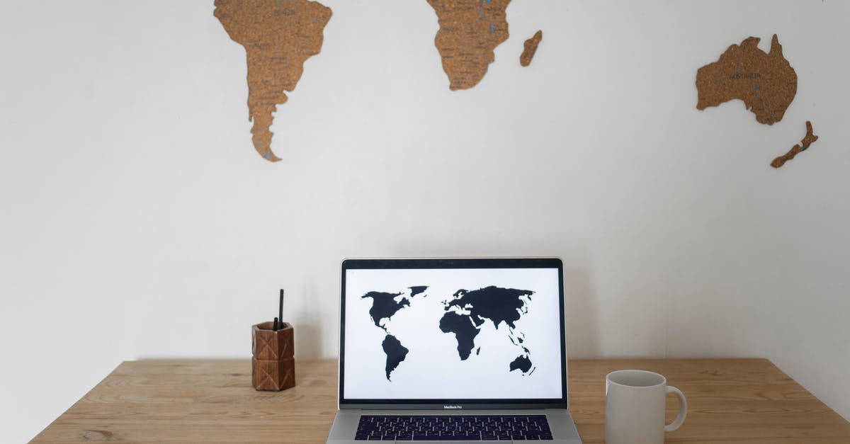 I want to play Minecraft with my friend in my world but it always says unable to join world on their screen [duplicate] - Black world map on laptop screen and ceramic cup with pen container placed on table against silhouettes of continents