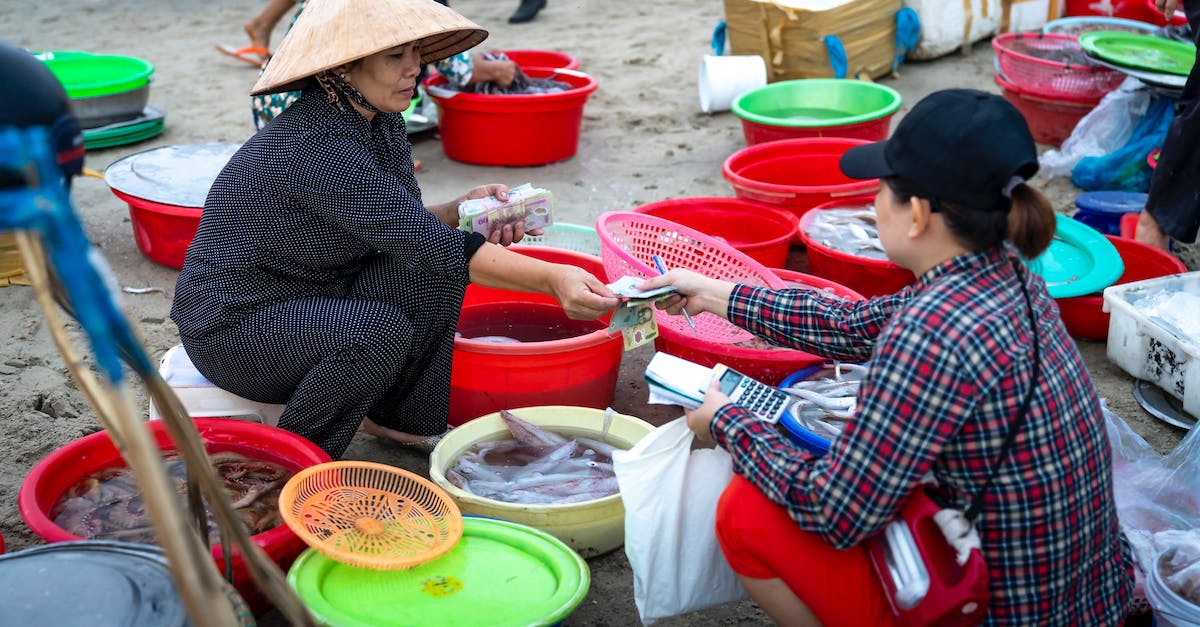 I want to sell a non-marketable hat in TF2. Is there any way to go about it? [closed] - Asian female in traditional authentic Vietnamese hat sitting on stool in street fish market and selling seafood to female customer