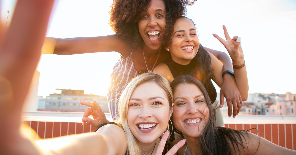 Identify relationship building dialog? - Cheerful young diverse women showing V sign while taking selfie on rooftop