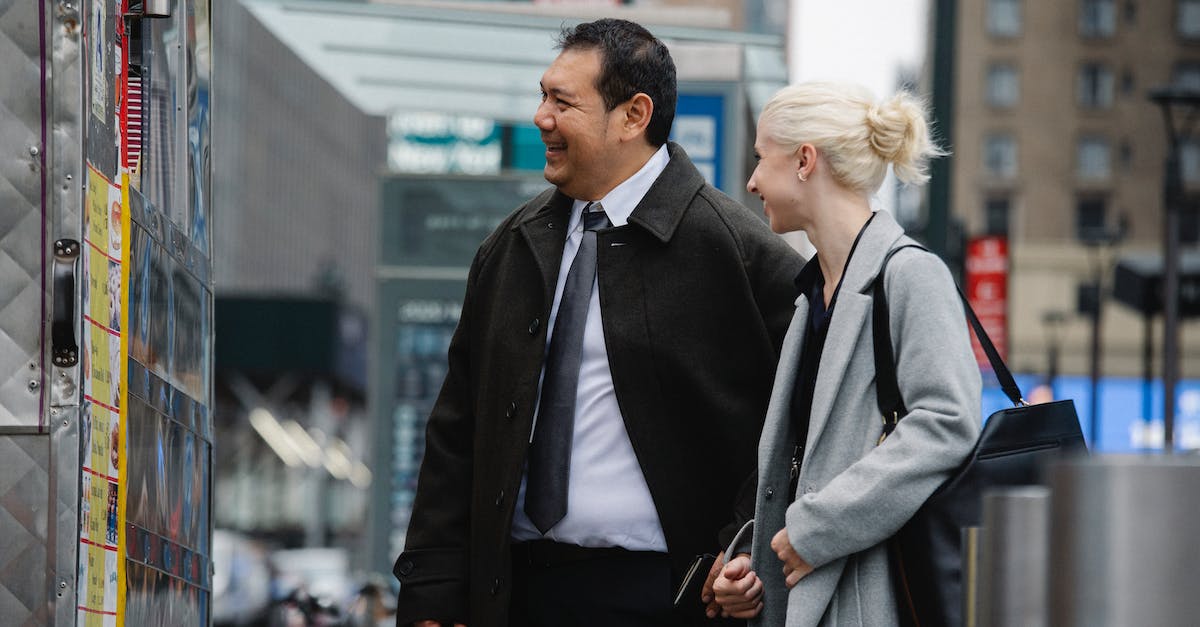 If I buy a shared game, will it stop being shared? - Mature man and woman in business clothes buying food in street van while chatting happily If I buy a shared game, will it stop being shared? - Mature man and woman in business clothes buying food in street van while chatting happily