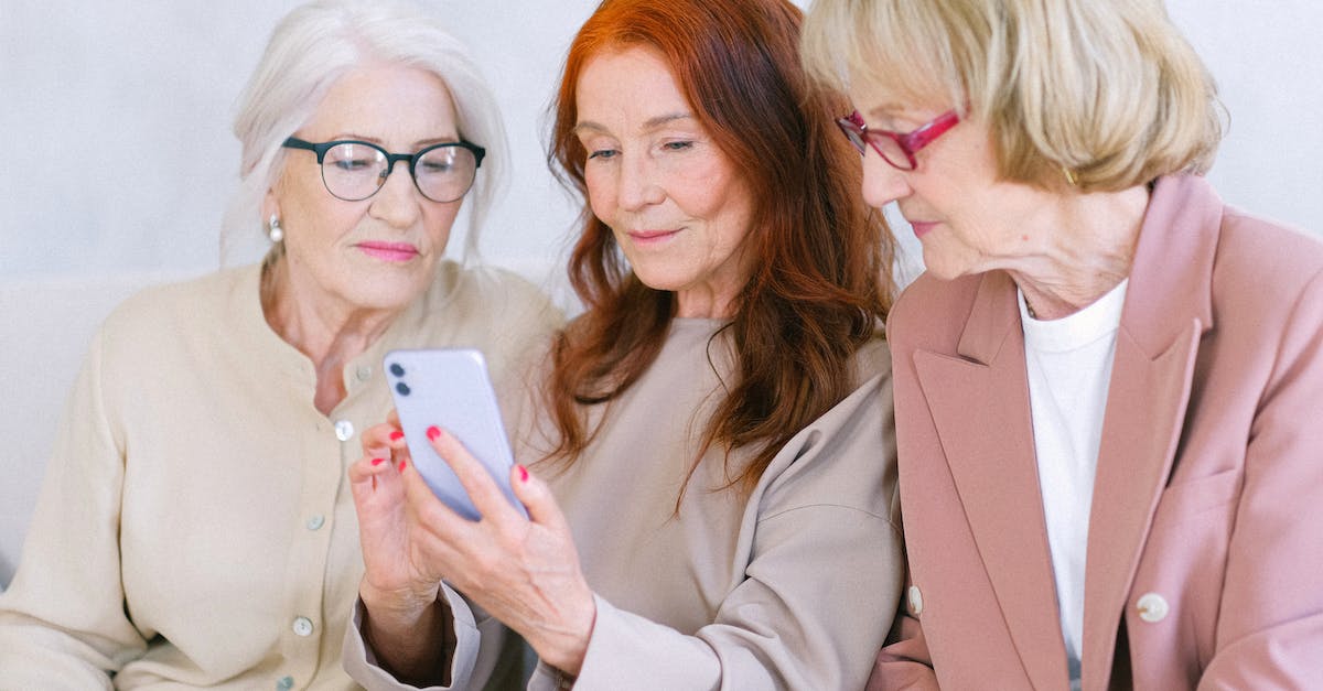 If I purchase PS Plus, do I get access to old PS Plus free downloads on another account? - Aged women using smartphone together