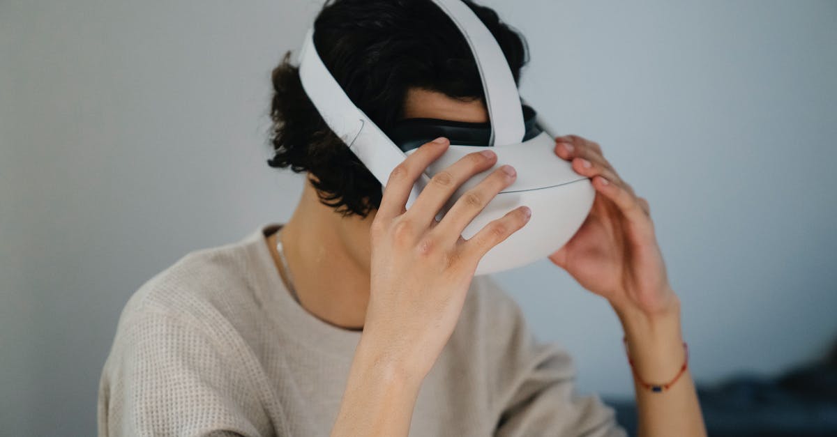 If I put my gamer ID into a preowned new 3ds Xl that has games already downloaded, will the games be affected in any way? - Unrecognizable young guy putting on modern VR glasses against gray wall at home If I put my gamer ID into a preowned new 3ds Xl that has games already downloaded, will the games be affected in any way? - Unrecognizable young guy putting on modern VR glasses against gray wall at home