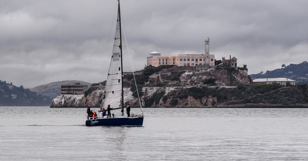 Impossible to manage castle - White and Blue Boat on Sea Near Brown Concrete Building Under Gray Sky Impossible to manage castle - White and Blue Boat on Sea Near Brown Concrete Building Under Gray Sky