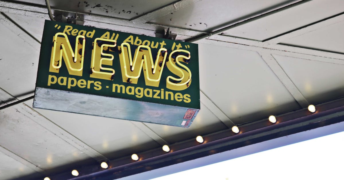 In Bidiots, what do the texts from the art buyers mean? - From below of illuminated signboard with news papers magazines inscriptions hanging on metal ceiling on street In Bidiots, what do the texts from the art buyers mean? - From below of illuminated signboard with news papers magazines inscriptions hanging on metal ceiling on street