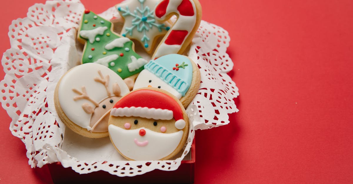 In candy box 2 what do the symbols on the status bar corners mean? - High angle of small box with Christmas biscuits decorated with colourful icing on white doily In candy box 2 what do the symbols on the status bar corners mean? - High angle of small box with Christmas biscuits decorated with colourful icing on white doily