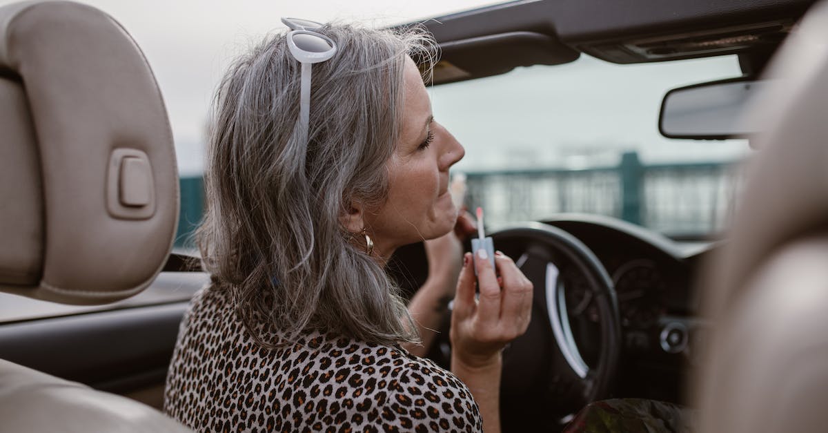 In GTA 4, does driving a particular vehicle make it appear more often? - Side view of middle aged female with gray hair in stylish outfit applying lip gloss while driving modern cabriolet In GTA 4, does driving a particular vehicle make it appear more often? - Side view of middle aged female with gray hair in stylish outfit applying lip gloss while driving modern cabriolet