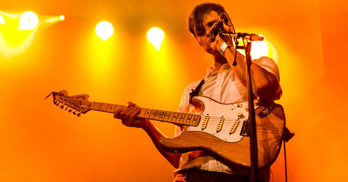 In maro party 10 for wii u is the RNG weighed aginst the lead player or is the RNG pure? - Low angle of young male musician playing electric guitar and singing song during concert in club with neon lights on background