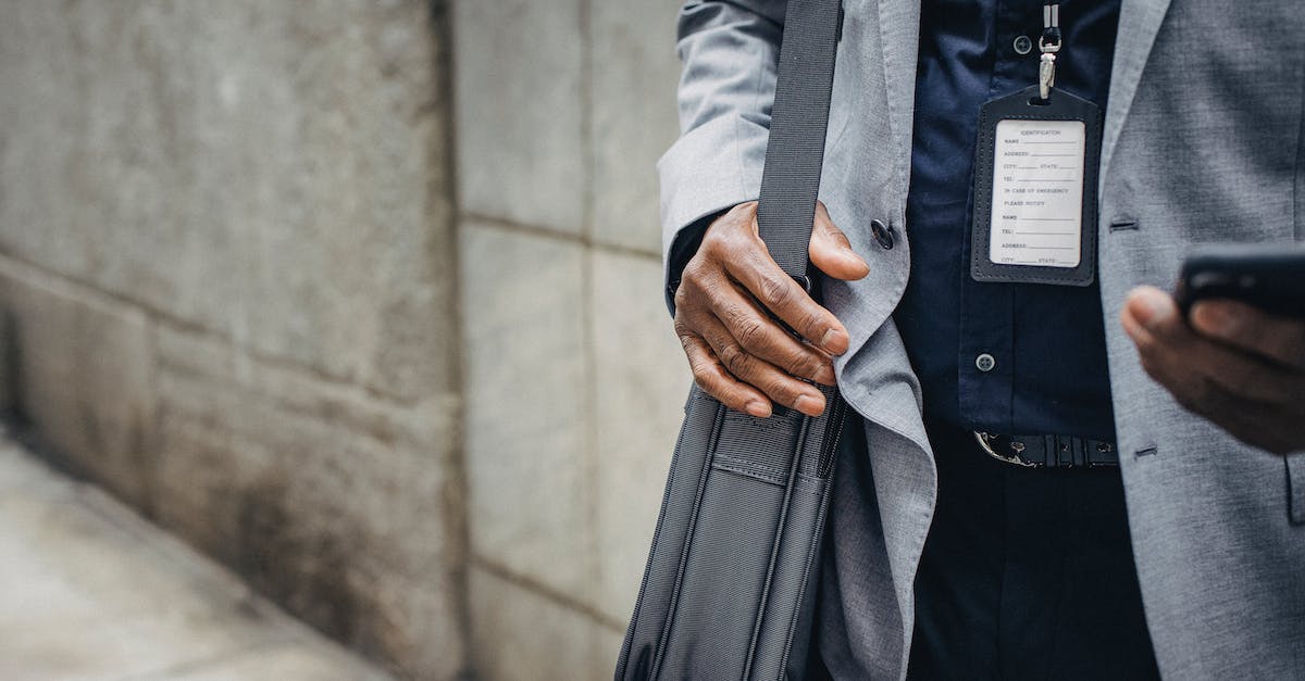 In the card crafting UI, is it possible to search for cards that I do not own - Crop anonymous African American entrepreneur in gray jacket with satchel and pass card browsing internet on smartphone on pavement near stone wall in city in daylight