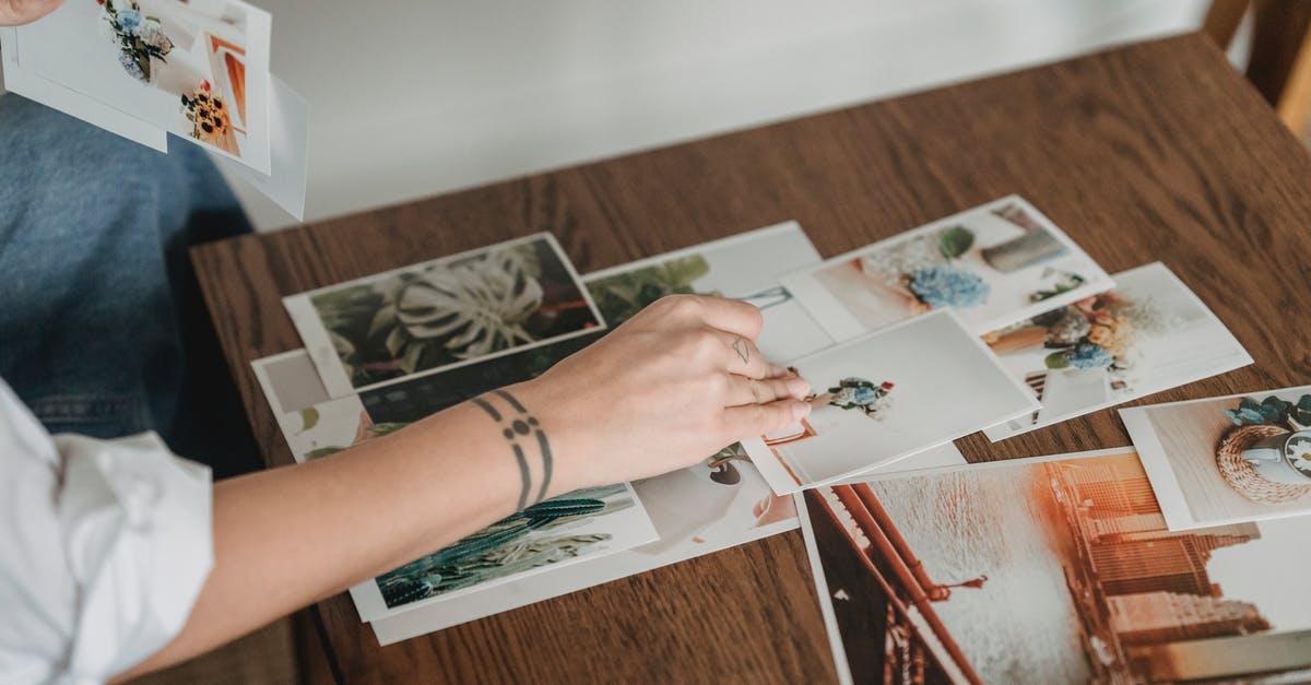In the river section, does different paths change anything? - Crop anonymous tattooed female with different photos of flowers and city at desk in house room In the river section, does different paths change anything? - Crop anonymous tattooed female with different photos of flowers and city at desk in house room