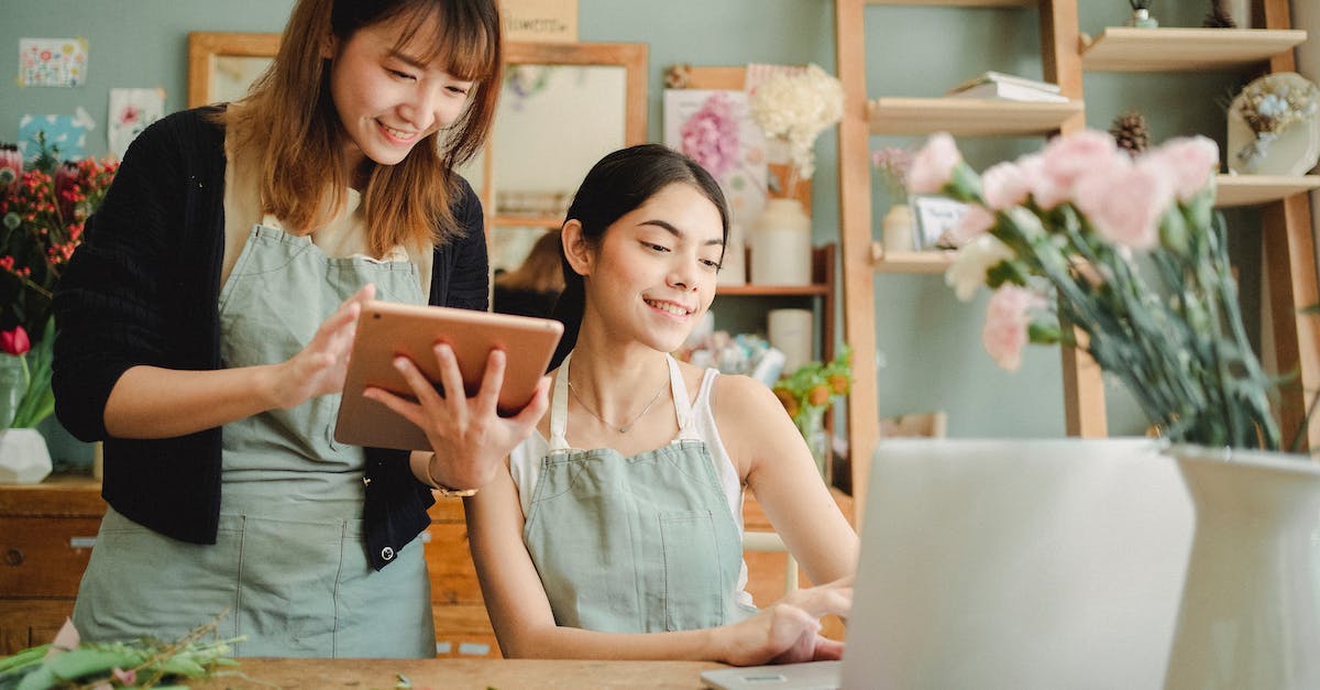 In what order do I have to rotate the extremties of the modron device? - Happy multiracial women working on gadgets in floral store