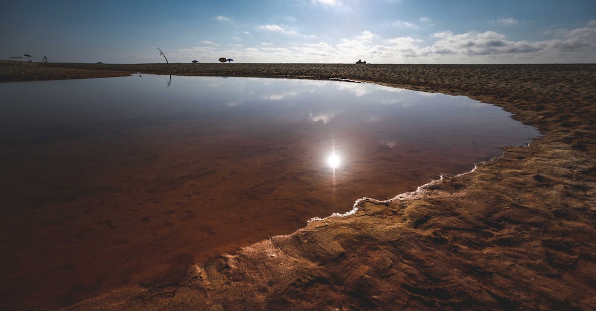Increase probability of lava lakes spawning in a superflat world - Picturesque view of pond in sandy desert under blue sky at sunny day