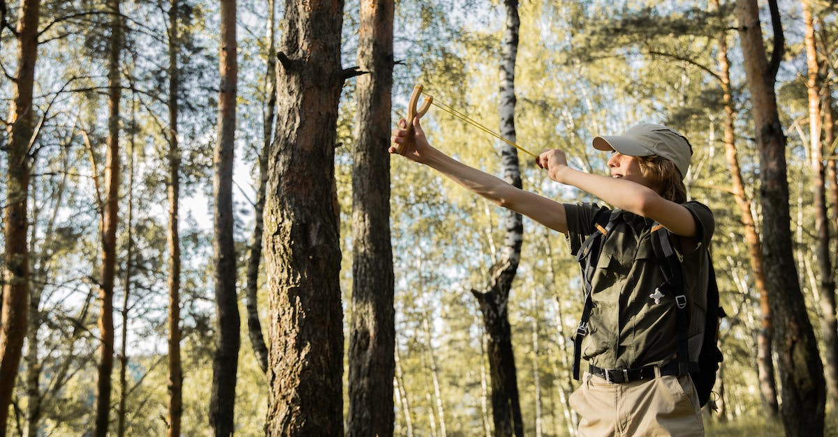 Increasing shooting skill at shooting range - Young Scout Shooting with a Slingshot in a Forest