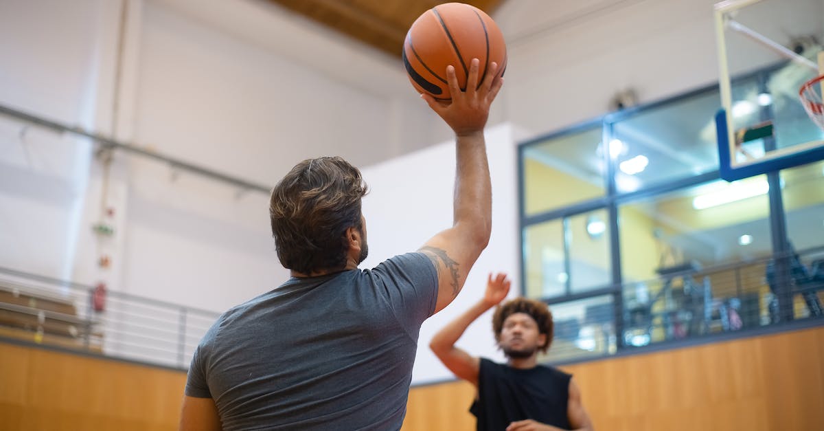 Increasing shooting skill at shooting range - Man in Blue T-shirt Holding Basketball